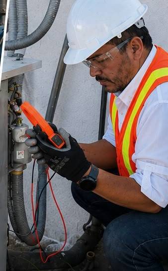 Técnico de ECOLAF diagnosticando con multímetro una falla eléctrica en un aire acondicionado