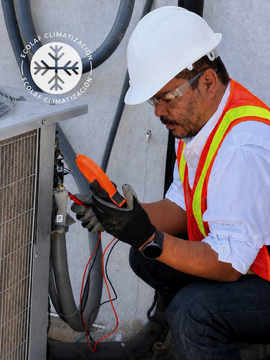 Técnico de ECOLAF Climatización midiendo con multímetro el sistema eléctrico de una unidad de aire acondicionado